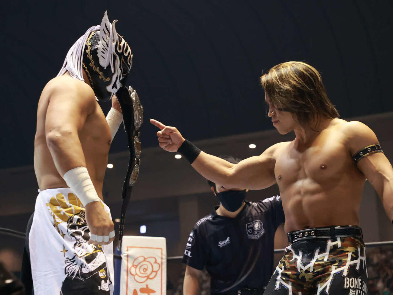 ベルトを見せつけるデスペラード（左）に指をさす石森（新日本プロレス提供）