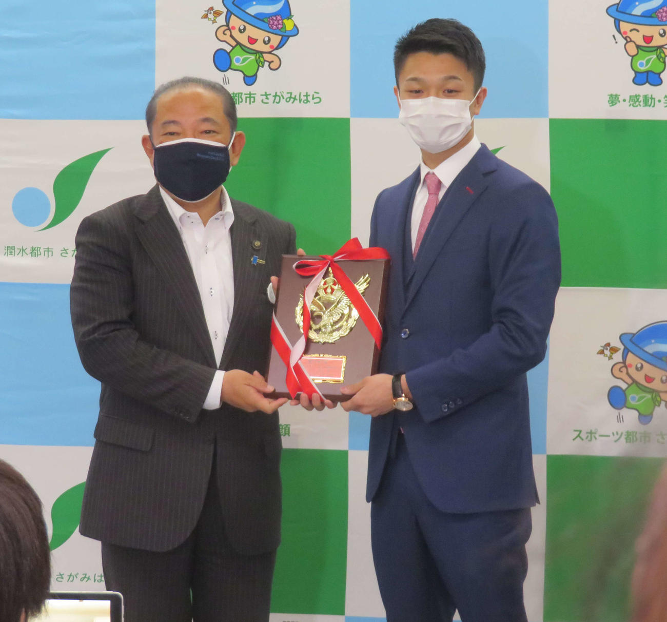 相模原の本村市長（左）からV2防衛成功の「称賛の盾」を贈られたWBO世界フライ級王者中谷