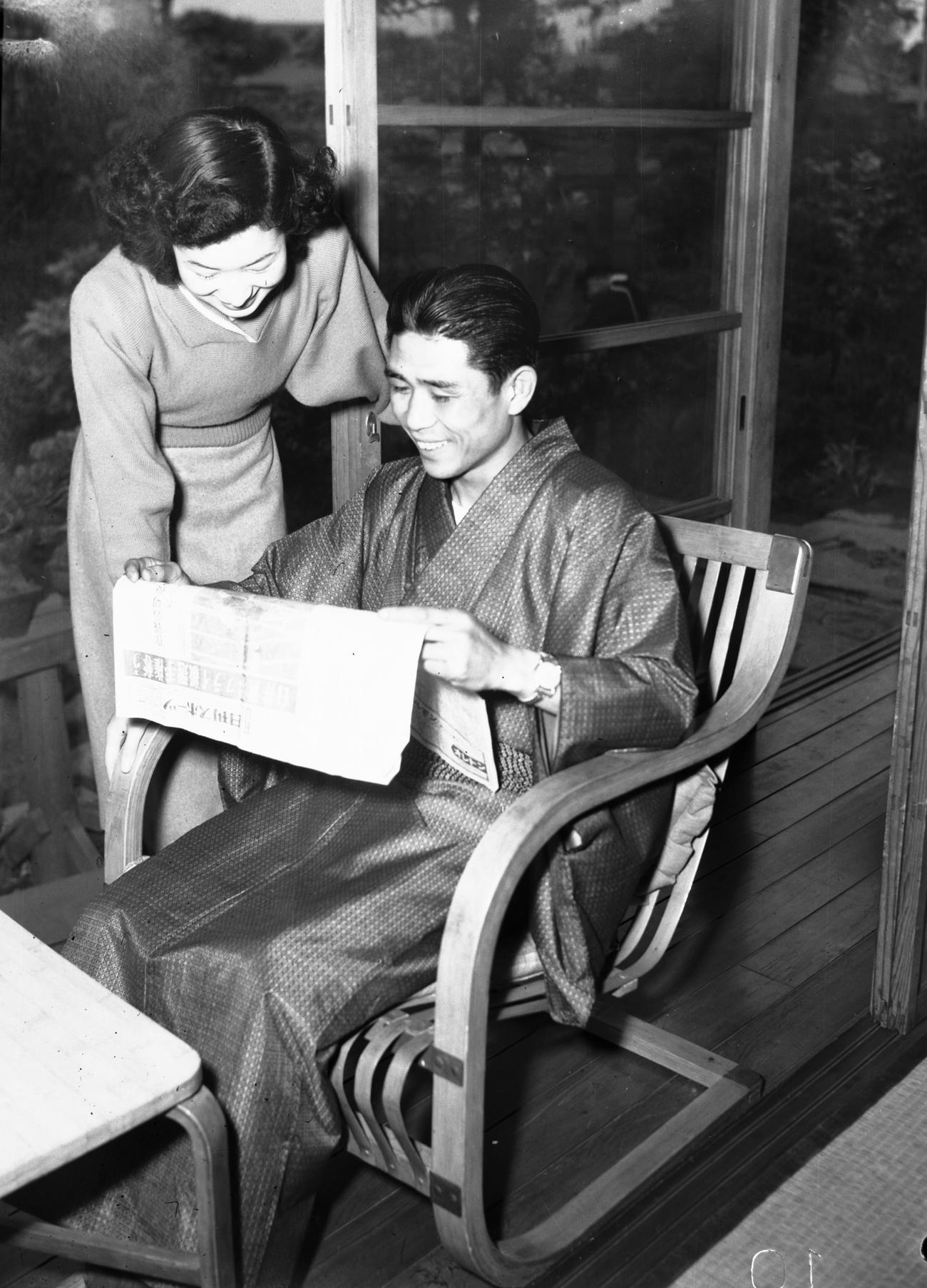 52年5月、世界フライ級選手権から一夜明け、自身の世界王座獲得を報じる日刊スポーツを読む白井義男と婚約者の登志子さん