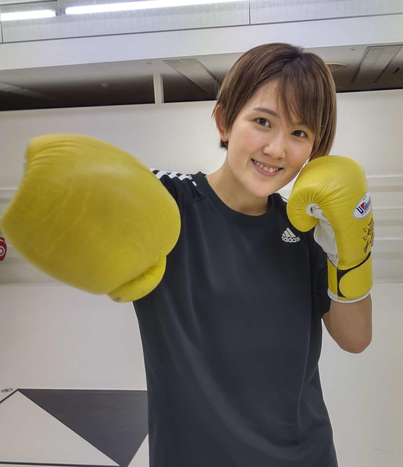 自慢の右ストレートのポーズを決めるMIO（撮影・吉池彰）