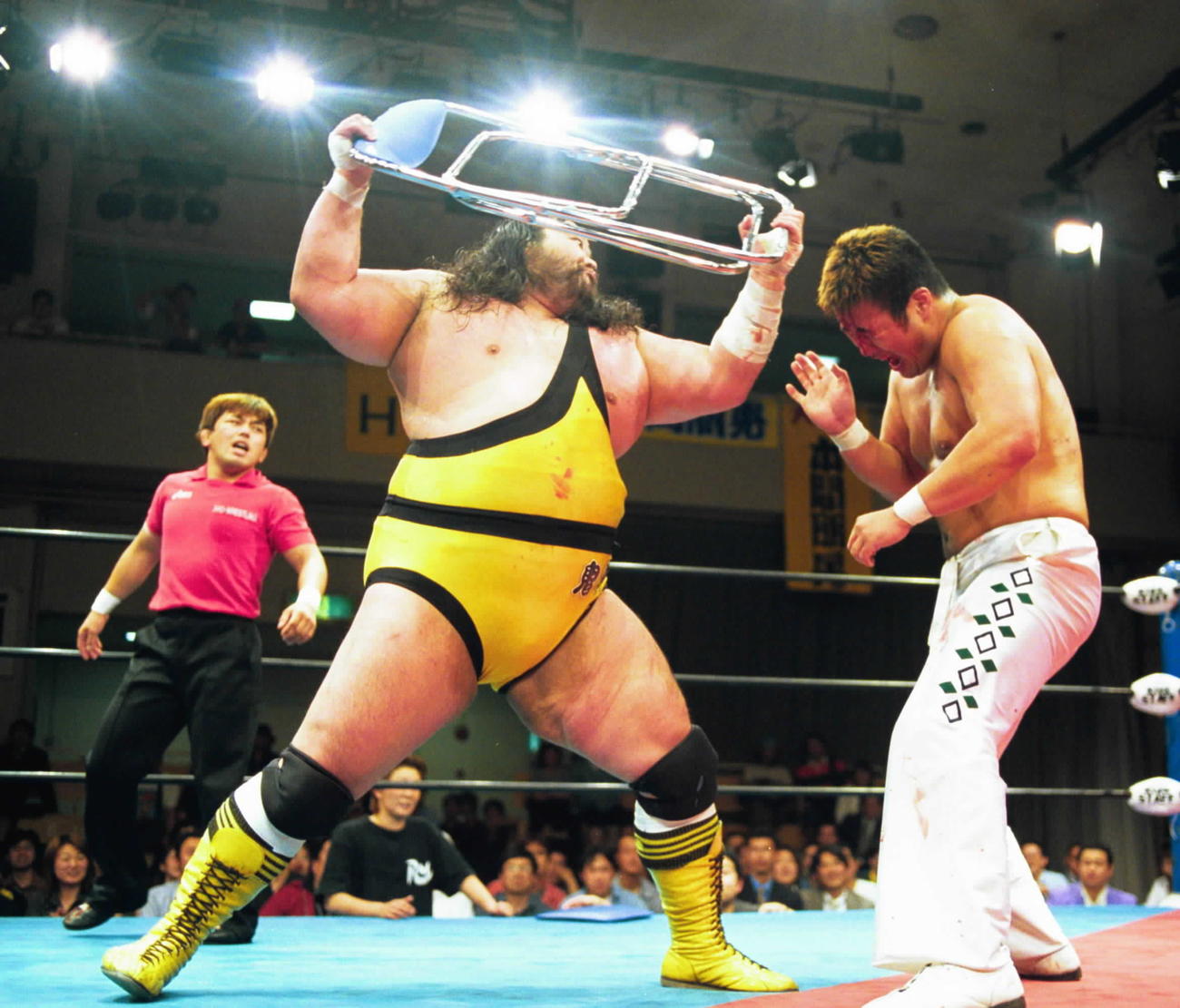 2001年5月、ターザン後藤さん（左）は本間朋晃にイスを投げつけ攻め込む