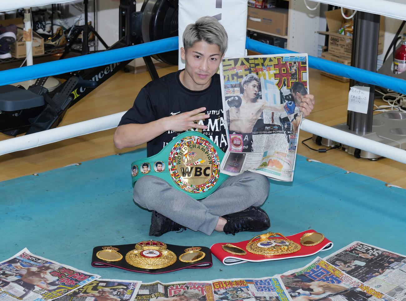 3団体王座統一の快挙から一夜明け、日刊スポーツを手に笑顔を見せる井上尚（撮影・菅敏）