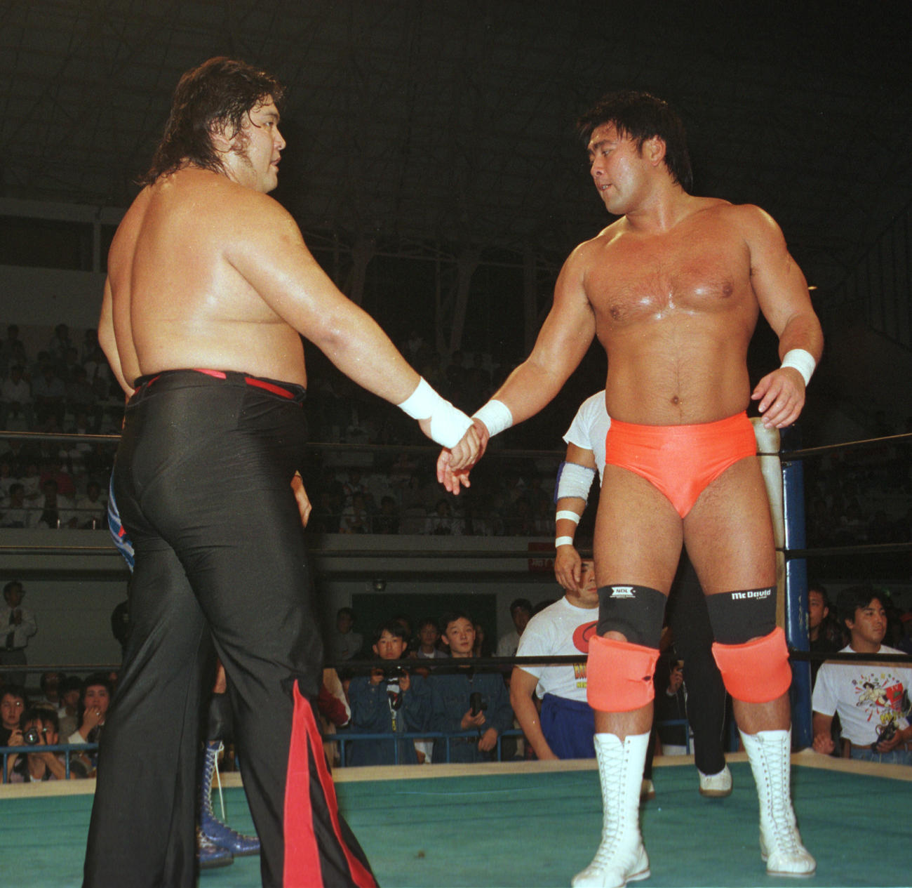 タッグ戦で対戦し、試合後に握手を交わす橋本真也（左）と武藤敬司＝1994年10月18日
