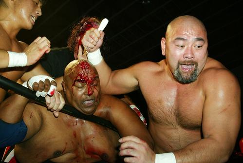 電子カメラ　全日本福島大会　アブドーラ・ザ・ブッチャー（中）のフォークを奪った武藤敬司（右）は、珍しくチョーク攻撃を食らわせた。左は宮本和志（2002年10月23日）
