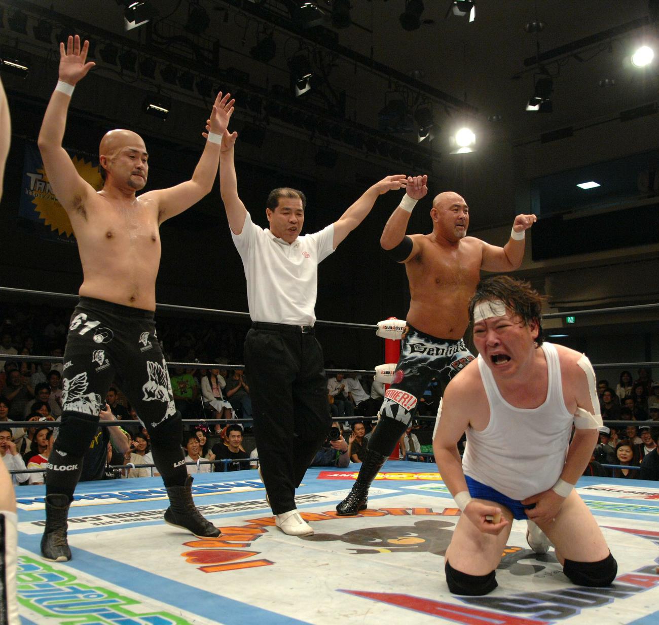 全日本後楽園大会　アツアツおでんをこ間に放り込まれた上島竜兵（手前右）は無念のギブアップ。勝ち名乗りを受ける神奈月（左）と武藤敬司（07年6月10日）