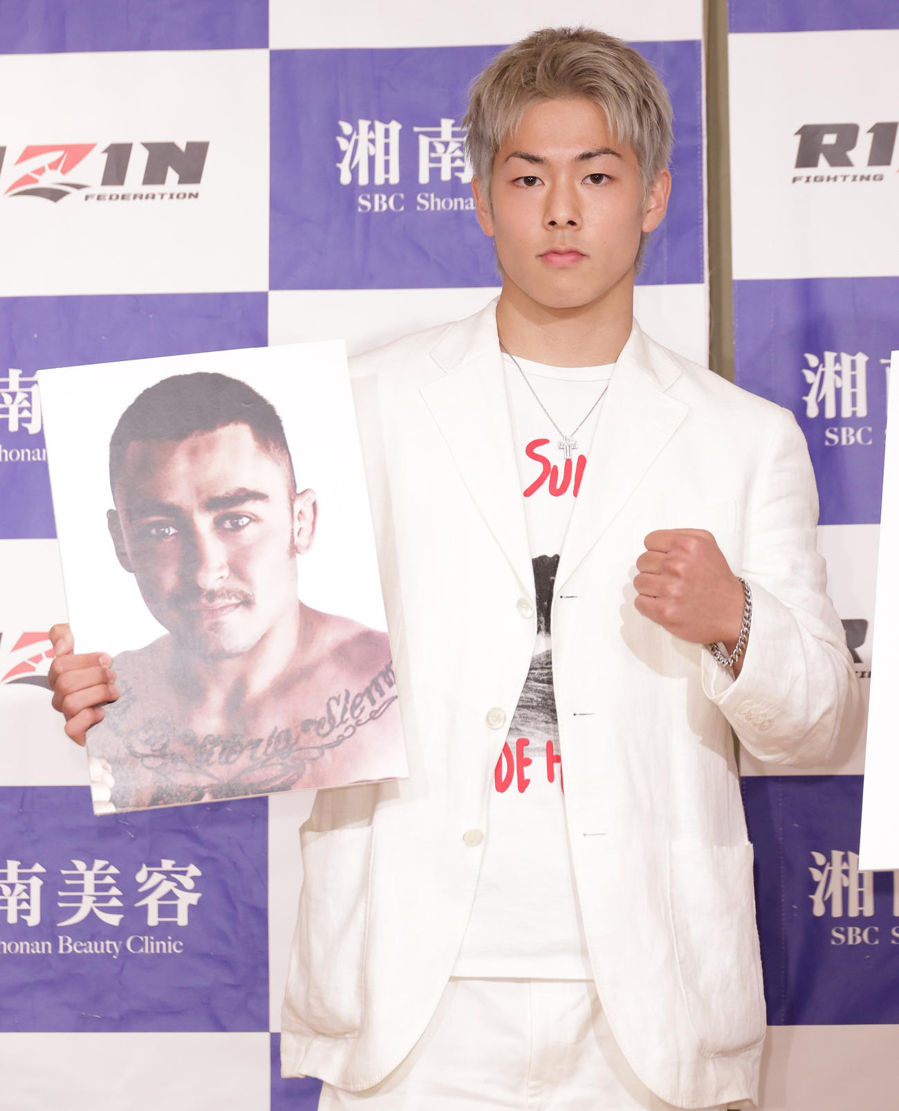 対戦相手のフェリペ“キングハンター”マソーニの写真を手にポーズを決める三浦孝太（撮影・中島郁夫）