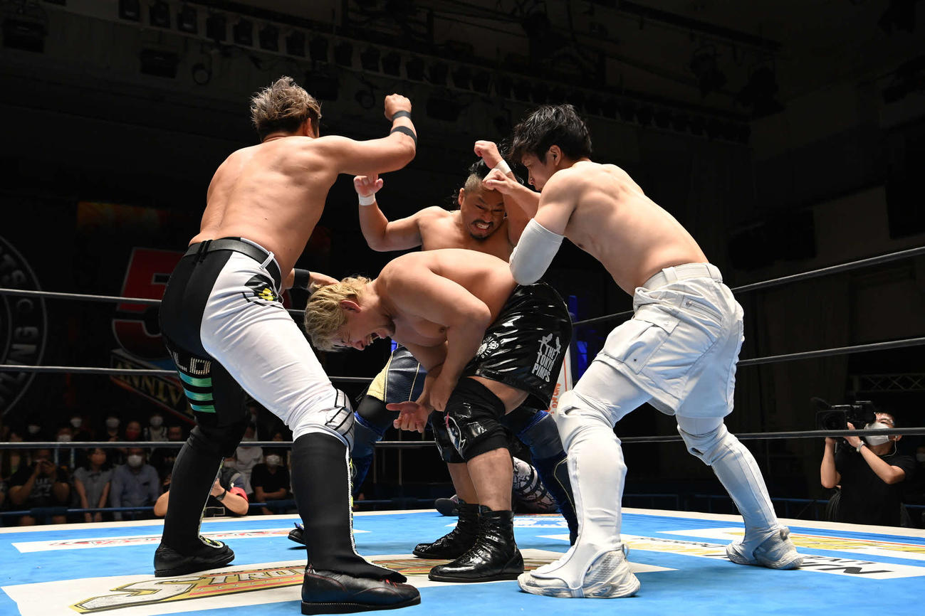 高橋裕（中央）に3人がかりで太鼓の乱れ打ちをを決めるケイオスの3人。左からYOSHI－HASHI、後藤、YOH（提供・新日本プロレス）