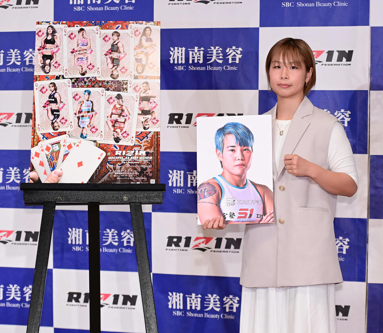 RIZIN37大会の追加対戦カード発表会見でパク・シウのパネルを手にファイティングポーズを見せる浅倉カンナ（撮影・小沢裕）
