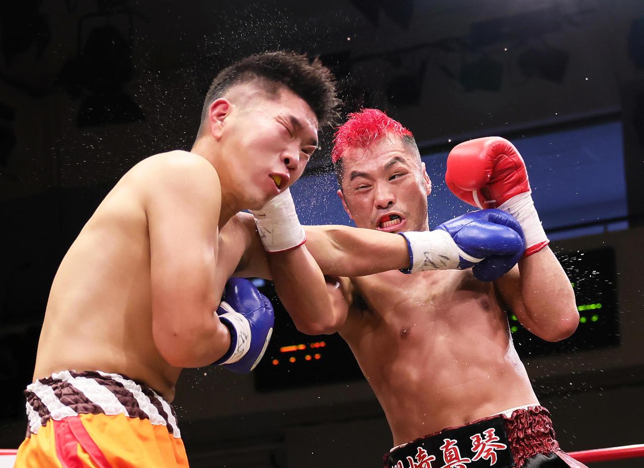 4回、川崎（右）は丸木に強烈な右パンチを浴びせる（撮影・足立雅史）