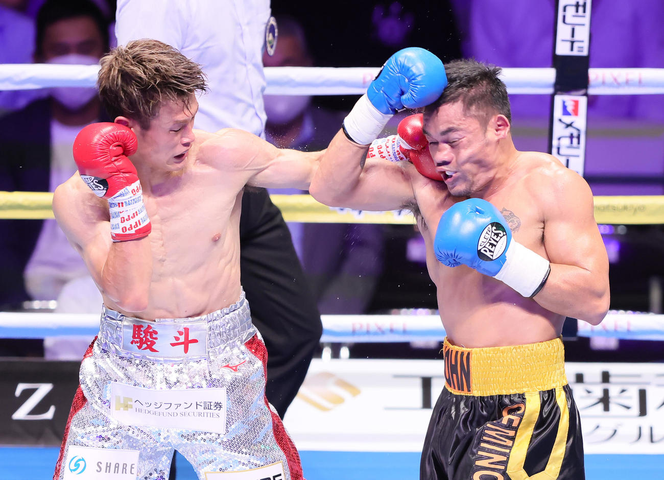 5回、堤（左）はジョン・ジェミノに強烈なパンチを見舞う（撮影・足立雅史）