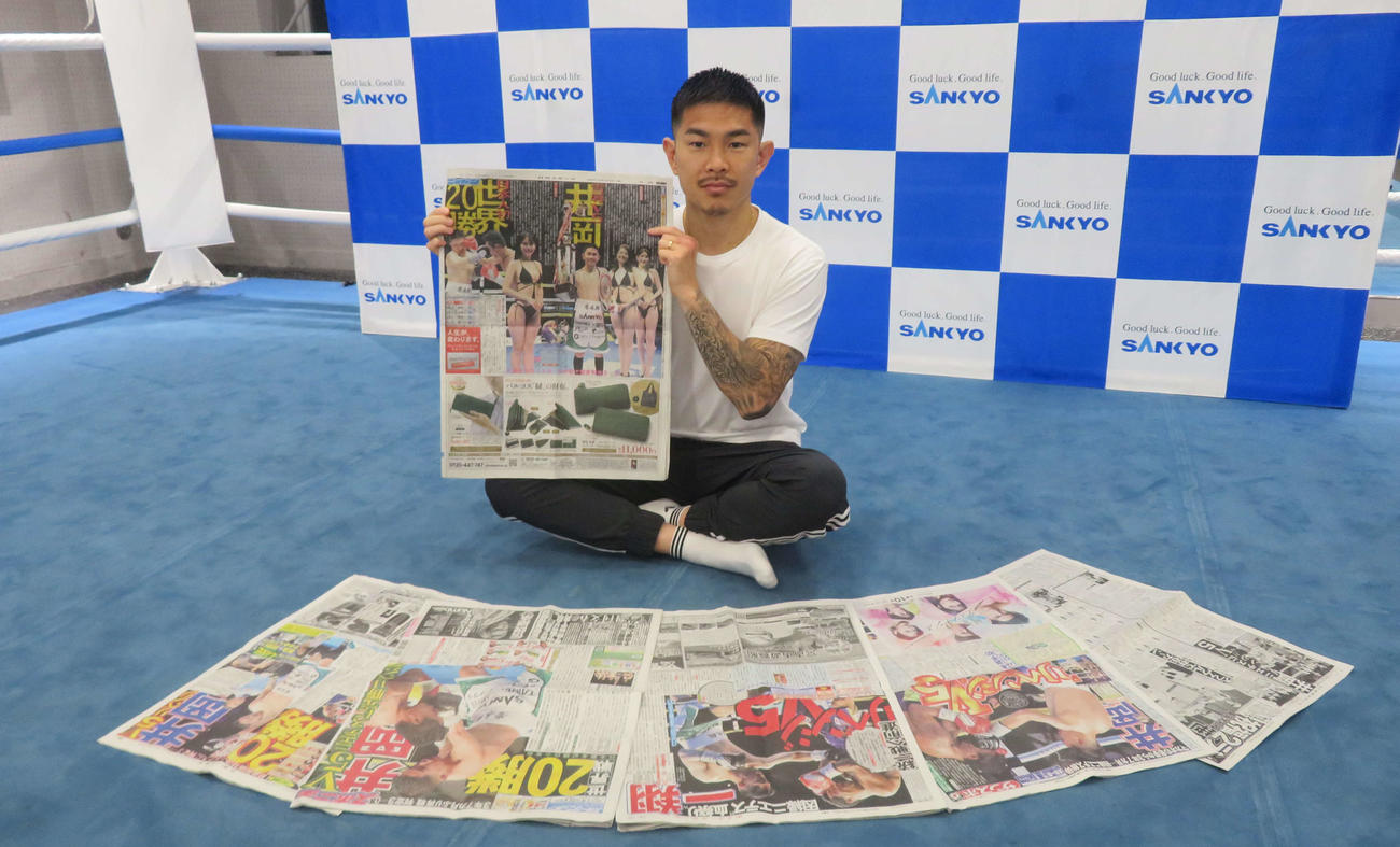 世界戦通算20勝目を伝えるスポーツ紙を手にするWBO世界スーパーフライ級王者井岡一翔