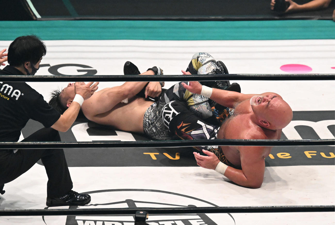 清宮海斗（左）の足4の字固めに苦痛の表情を見せる武藤敬司（撮影・滝沢徹郎）