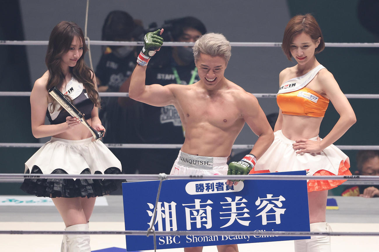 YUSHI対覇留樹　勝利したYUSHI（中央）はRIZINガールの東海林里咲（左）、あきぴと写真に納まる（撮影・垰建太）