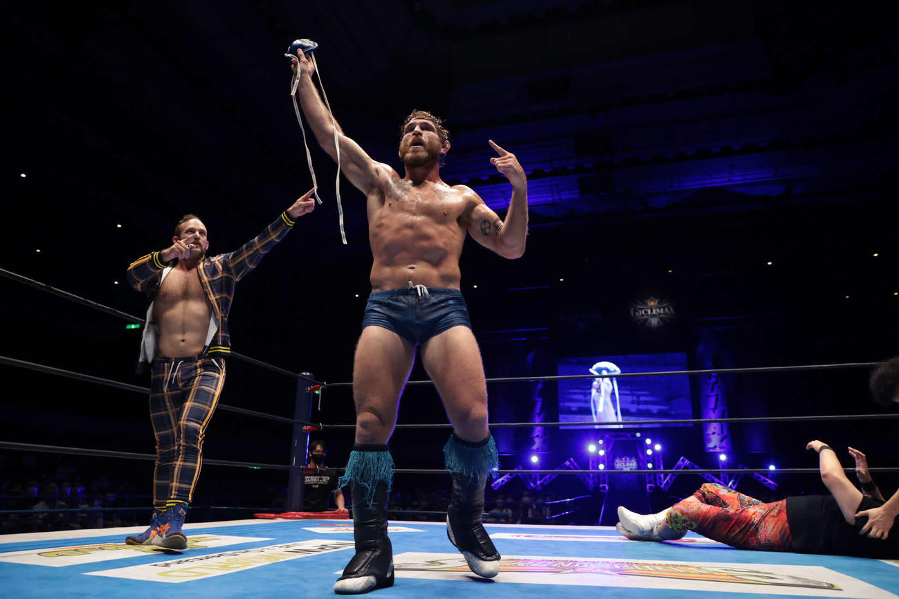 ファールカップを掲げるローラー（中央）とパートナーのアイザックス（提供・新日本プロレス）