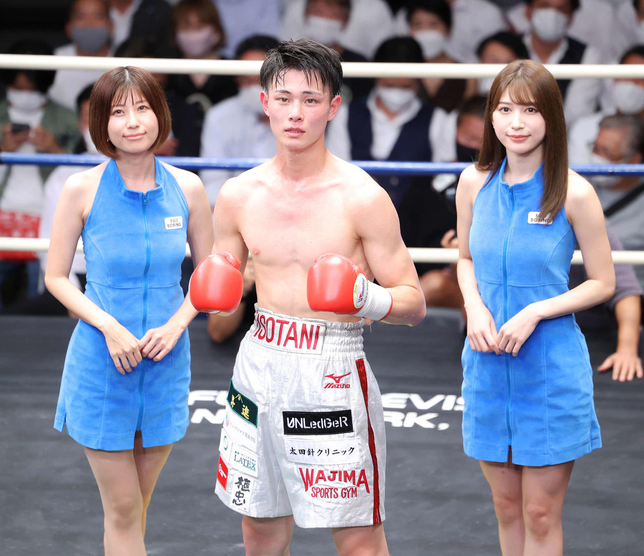 田中に勝利し、写真に納まる磯谷（中央）。左はリングガールの天野麻菜、右は雪平莉左（撮影・河田真司）