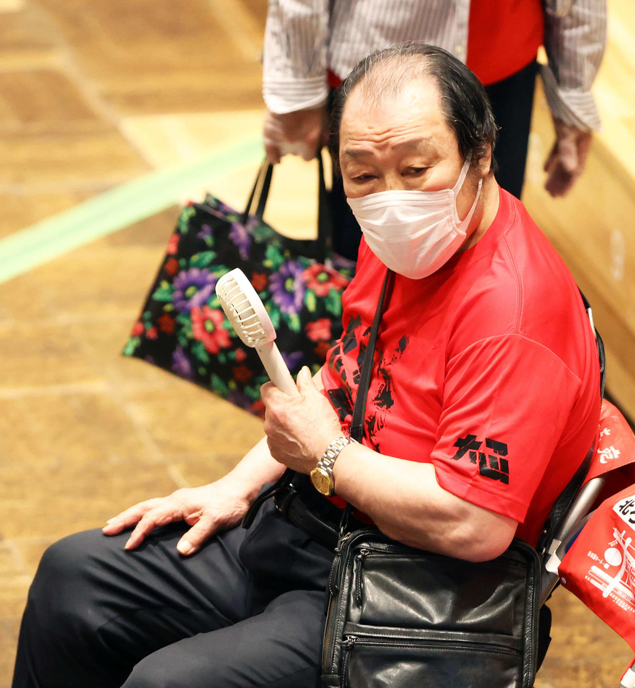 試合開始前、ミニ扇風機の風を浴びる輪島功一氏（撮影・河田真司）