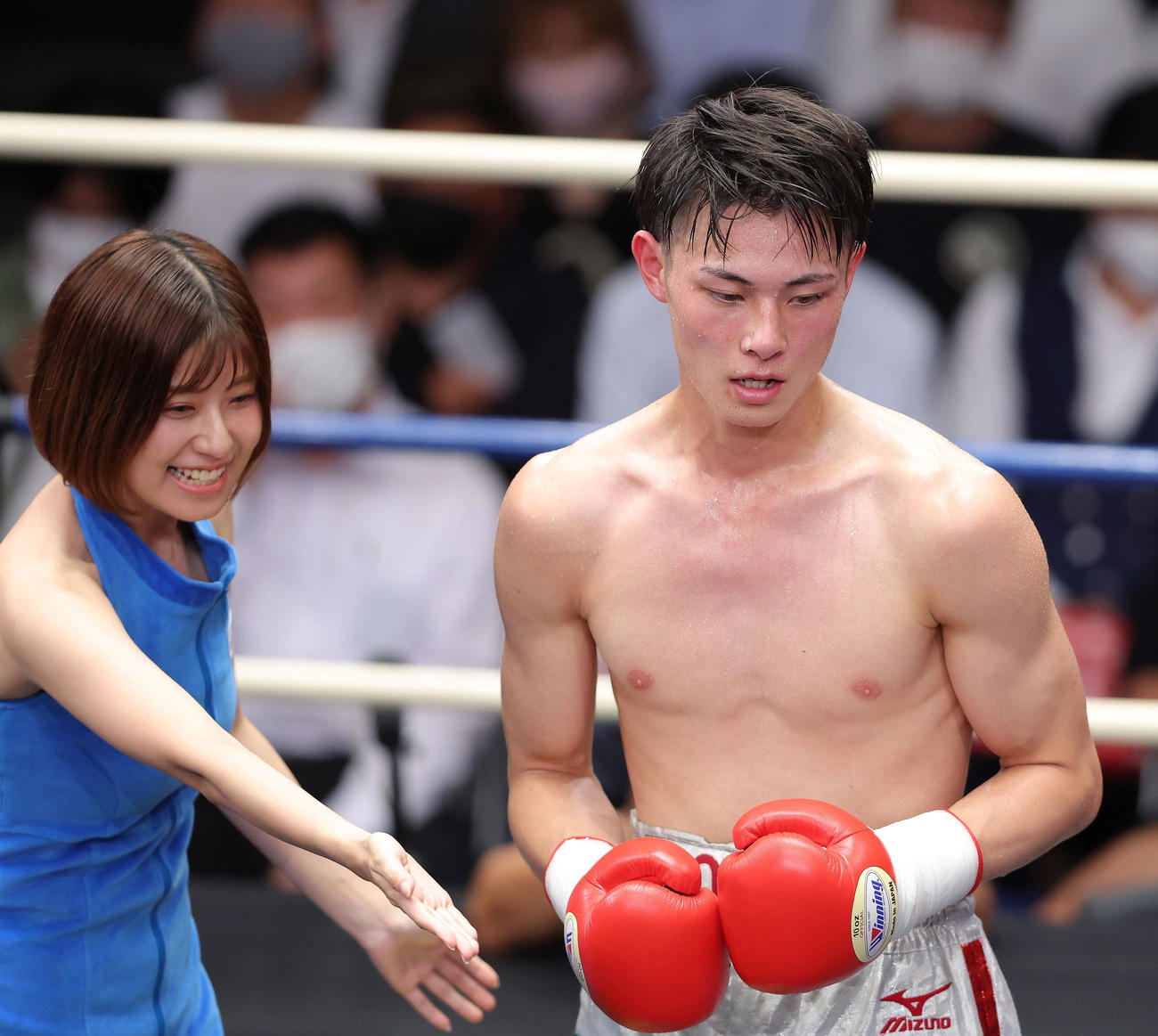 田中慧士に勝利し、リングガールの天野麻菜（左）に誘導される磯谷大心（撮影・河田真司）