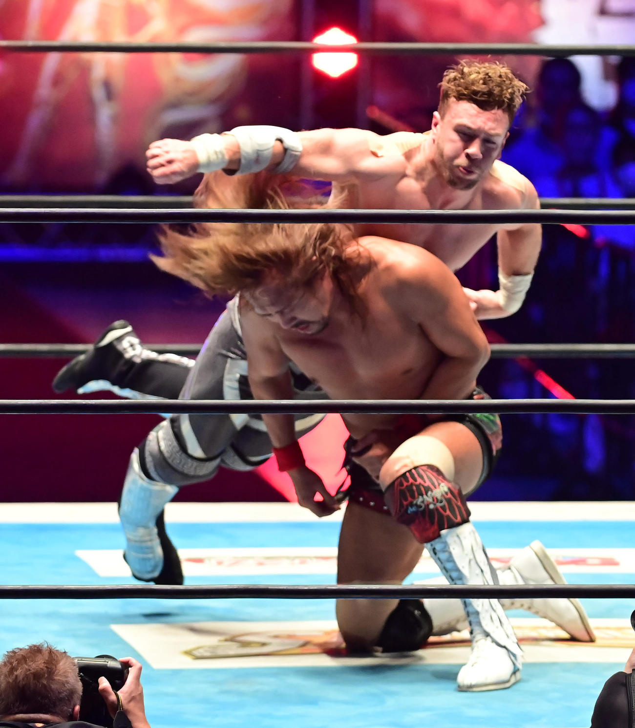 内藤（手前）の後頭部目がけてエルボーを放つオスプレイ（撮影・小沢裕）