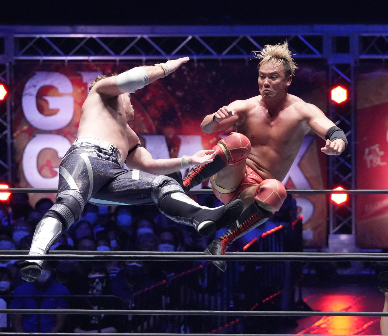 オカダ・カズチカ対ウィル・オスプレイ　ダイブするウィル・オスプレイ（左）にドロップキックで対抗するオカダ・カズチカ（撮影・小沢裕）