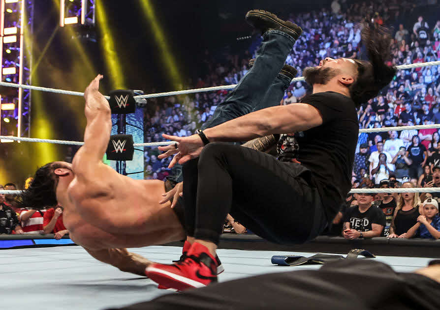 統一王者ローマン・レインズ（右）にクレイモアを蹴りこむドリュー・マッキンタイア（C）2022 WWE, Inc. All Rights Reserved.