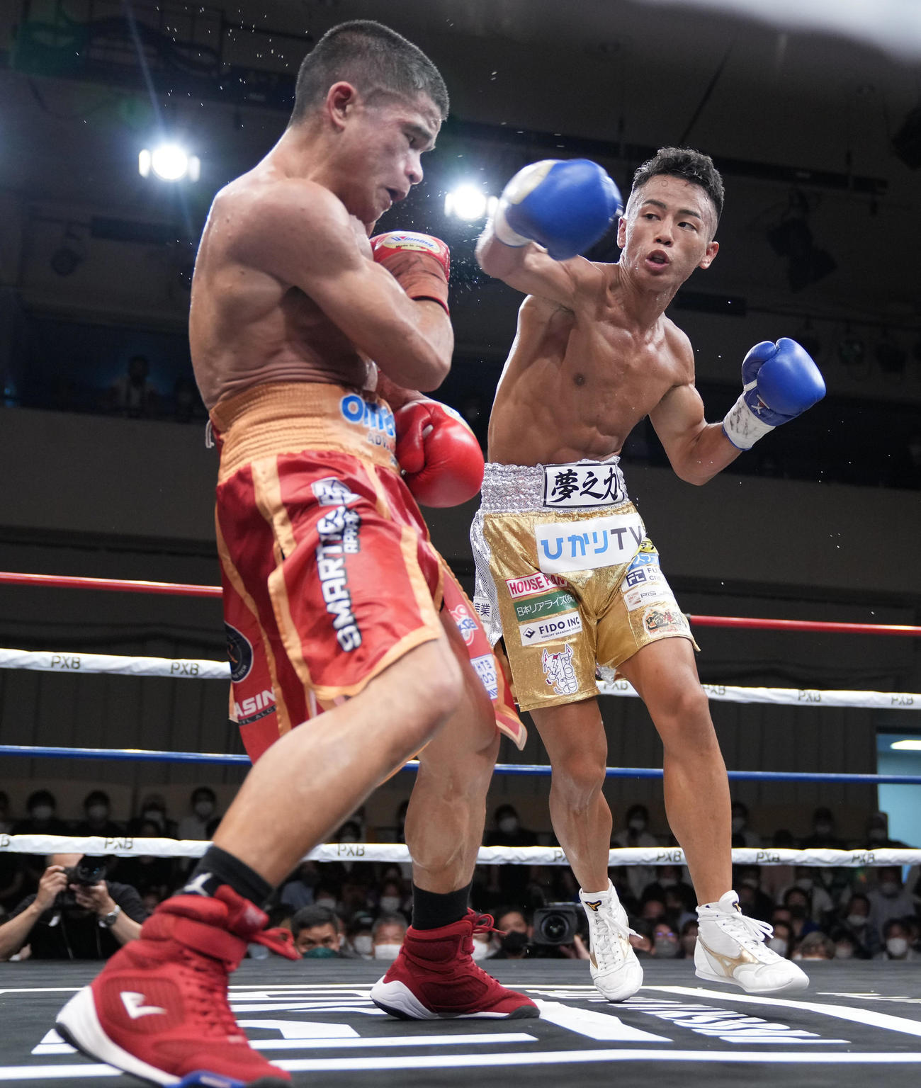 5回、ペテ・アポリナル（左）に右パンチを放つ武居（撮影・小沢裕）