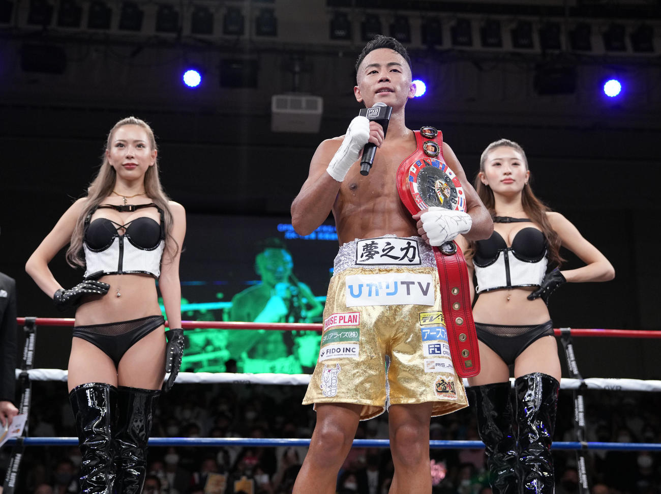 OPBF東洋太平洋スーパー・バンタム級新王者となりファンにあいさつする武居。左はラウンドガールのHARACHAN、右はMIYABI（撮影・小沢裕）