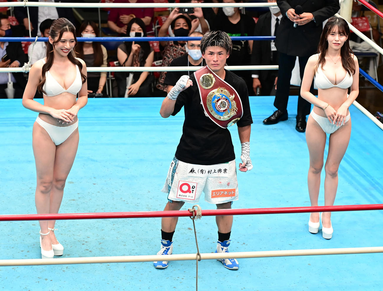 木村吉光対中川兼玄　12回、TKO勝ちを収めファイティングポーズを見せる木村。左はラウンドガールのSAYURI、右は雛乃ぽぽ（撮影・小沢裕）