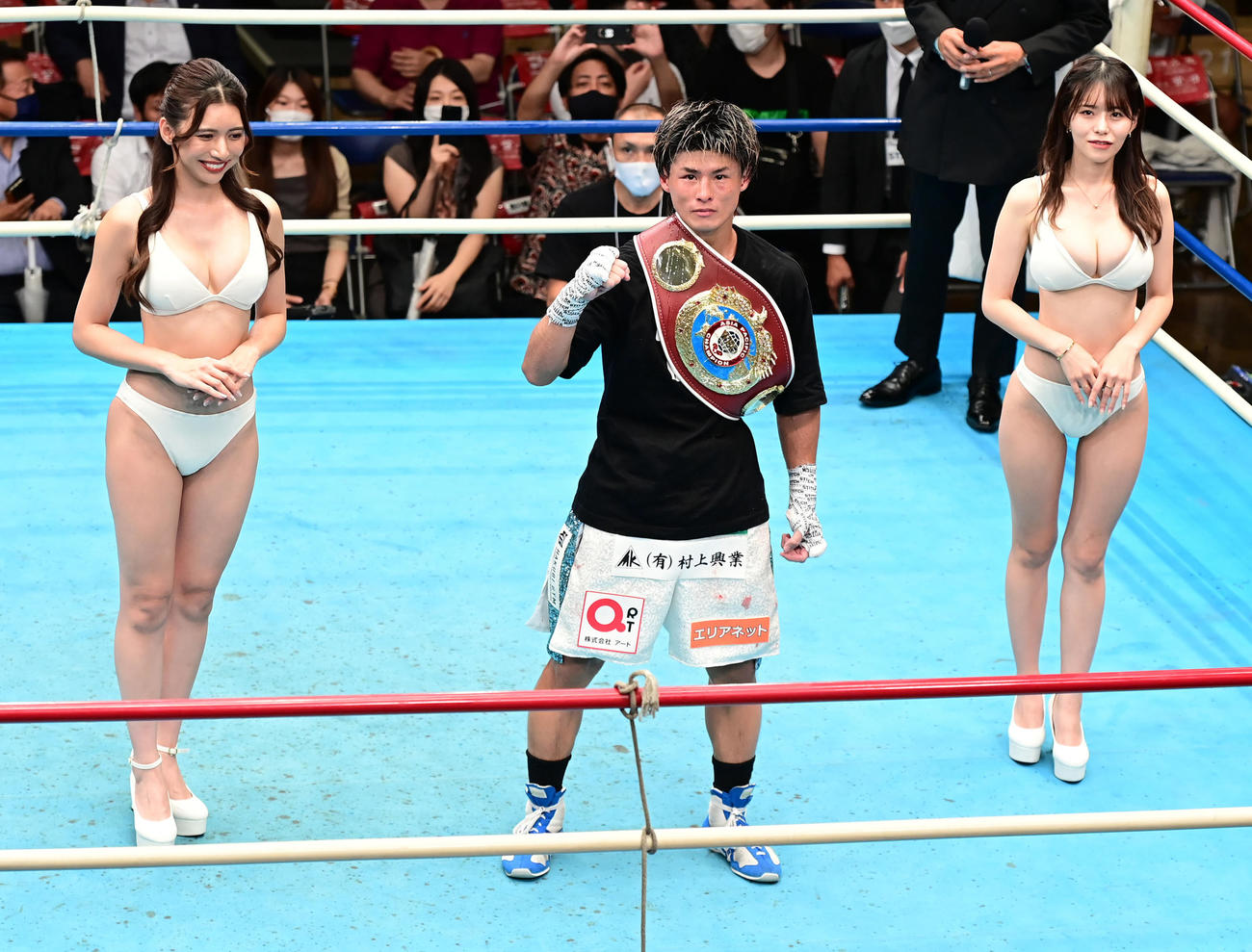 木村吉光対中川兼玄　12回、TKO勝ちを収めファイティングポーズを見せる木村。左はラウンドガールのSAYURI、右は雛乃ポポ（撮影・小沢裕）
