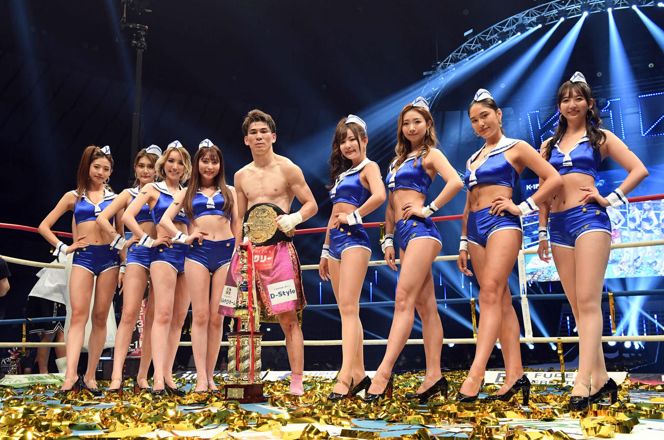 スーパーフェザー級王座決定戦トーナメント　5代目王座に輝いたレオナ・タペスは、K－1ガールズと笑顔で記念撮影（撮影・たえ見朱実）