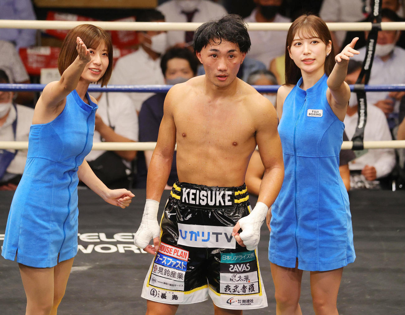 フェザー級8回戦　2回TKO勝ちした松本圭佑（中央）を祝福するラウンドガールの天野麻菜（左）と雪平莉左（撮影・野上伸悟）