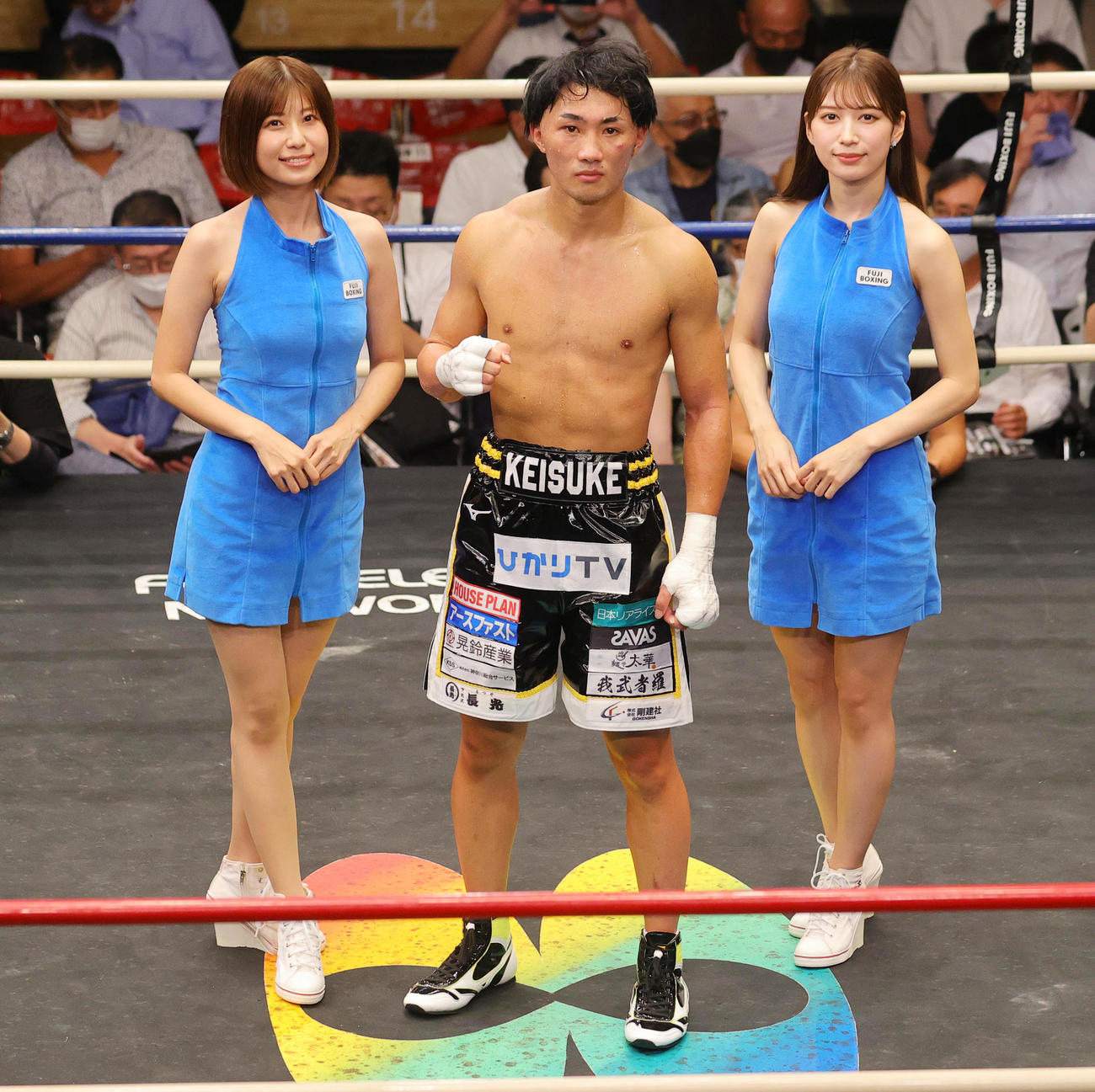 フェザー級8回戦　2回TKO勝ちした松本圭佑（中央）を祝福するラウンドガールの天野麻菜（左）と雪平莉左（撮影・野上伸悟）