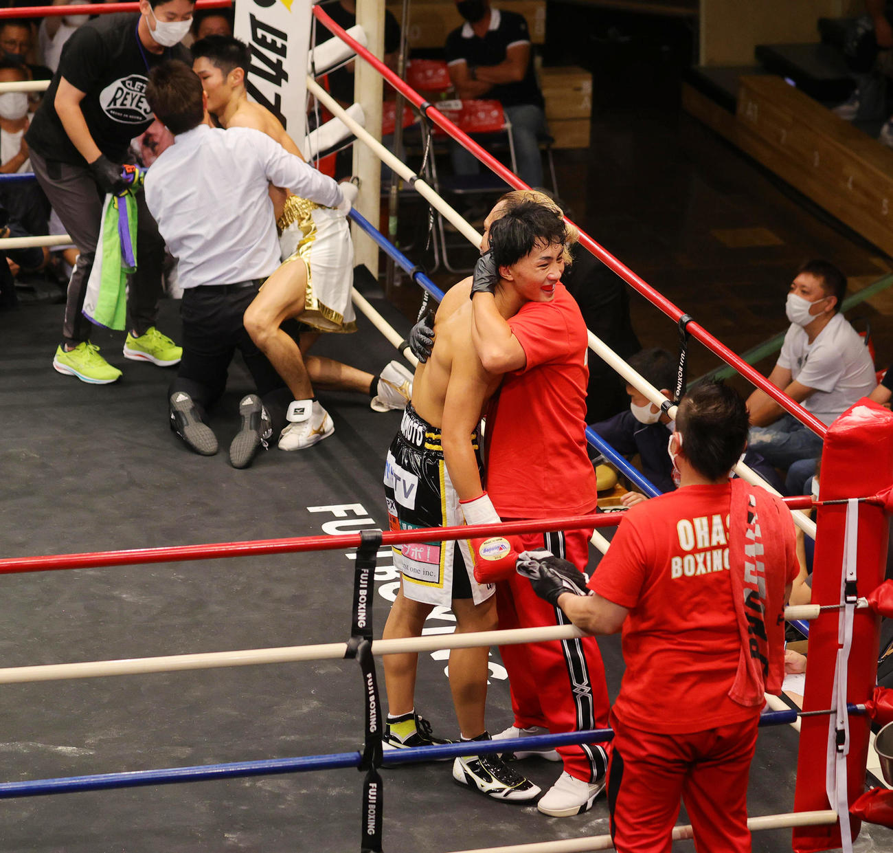 フェザー級8回戦　石田（後方右）に2回TKO勝ちし、父の好二トレーナー（手前右）と喜ぶ松本圭佑（撮影・野上伸悟）