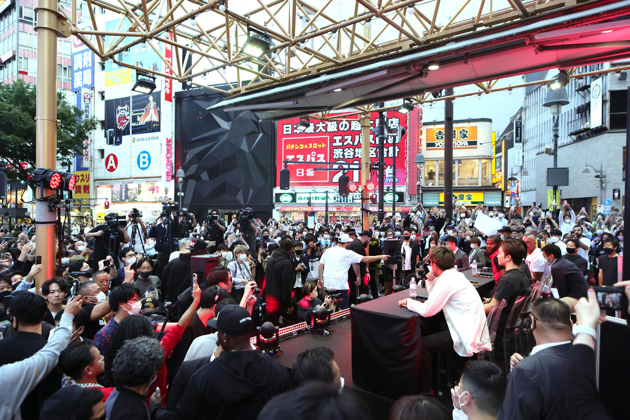 大勢の人たちの注目を集めながら、渋谷での会見に臨んだ朝倉（壇上中央右）とメイウェザー（同左）（撮影・足立雅史）