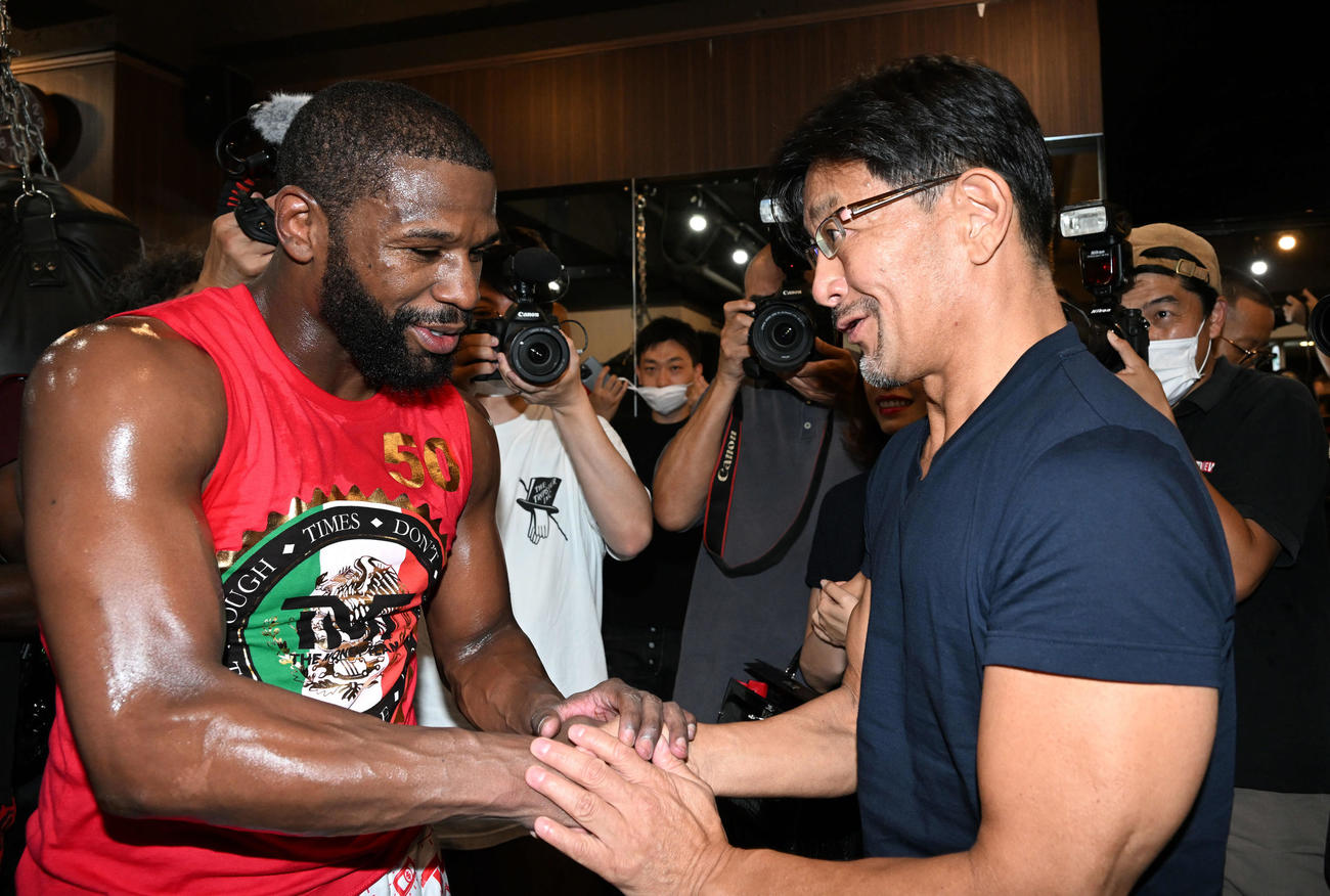 公開練習を終えたメイウェザー（左）は榊原CEOと握手を交わす（撮影・滝沢徹郎）