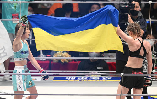 試合に勝利した伊沢星花（左）はアナスタシア・スヴェッキスカとウクライナ国旗を掲げる（撮影・滝沢徹郎）