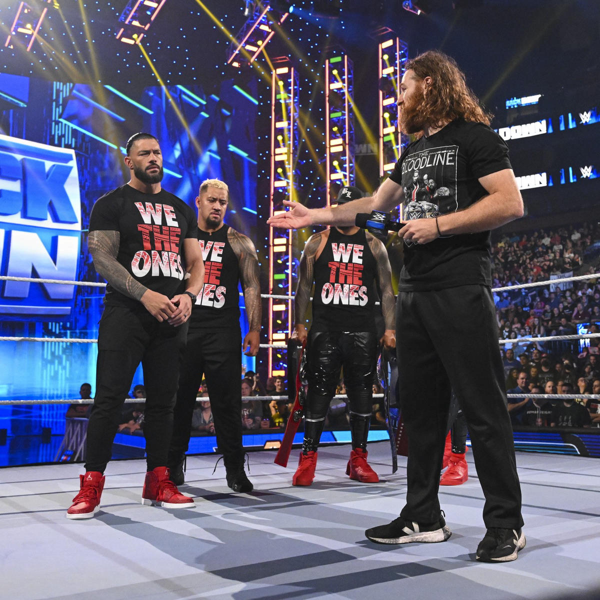 サミ・ゼイン（右端）に手を差し伸べられたWWEヘビー、ユニバーサル統一王者ローマン・レインズ（左端）（C）2022 WWE, Inc. All Rights Reserved