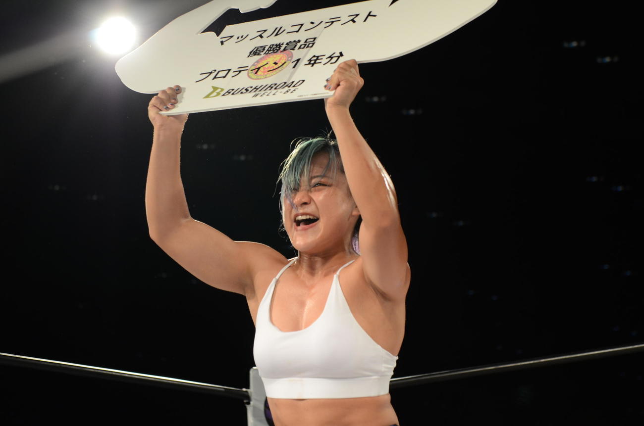 スターダム高田馬場大会　マッスルコンテストで優勝した飯田沙耶は賞品ボードを掲げる（撮影・松熊洋介）