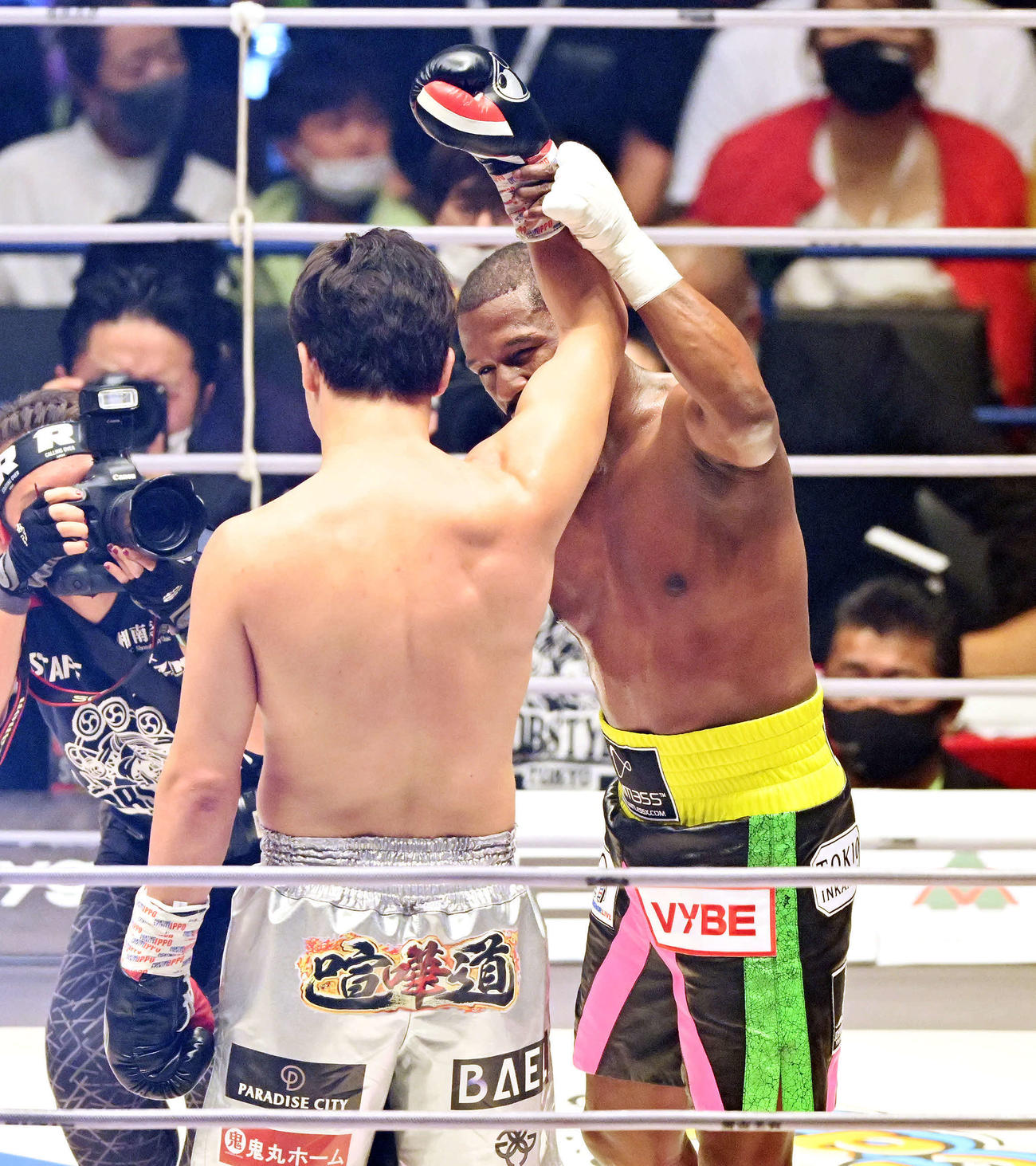 試合後、朝倉未来（手前）の右腕を上げをねぎらうフロイド・メイウェザー（撮影・滝沢徹郎）