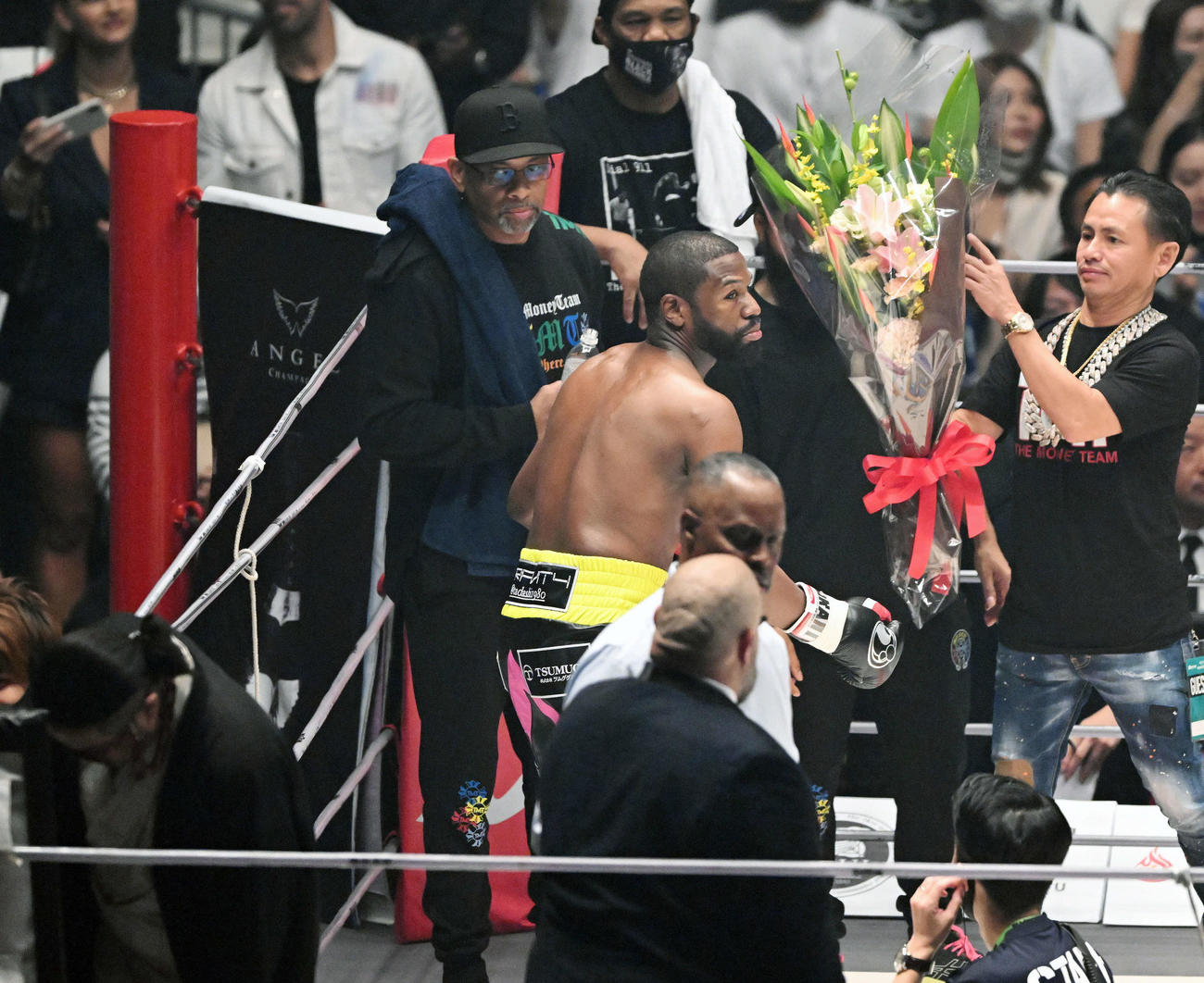 試合前にごぼうの党の奥野卓志氏（手前左）から投げ捨てられた花束を拾いセコンドに預けるフロイド・メイウェザー（2022年9月25日撮影）