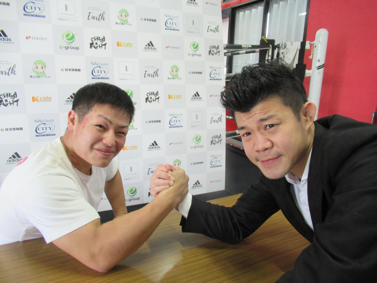 腕相撲勝負する亀田興毅ファウンダー（右）と中島