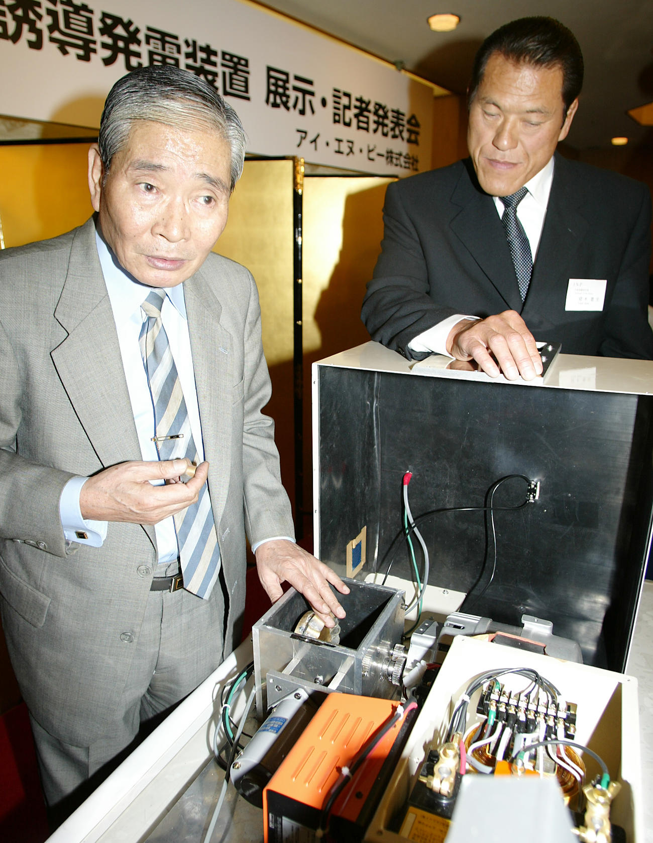 2002年3月11日、「INPー4（イノキナチュラルパワー4型）トルク誘導発電装置」を前に説明を聞くアントニオ猪木さん