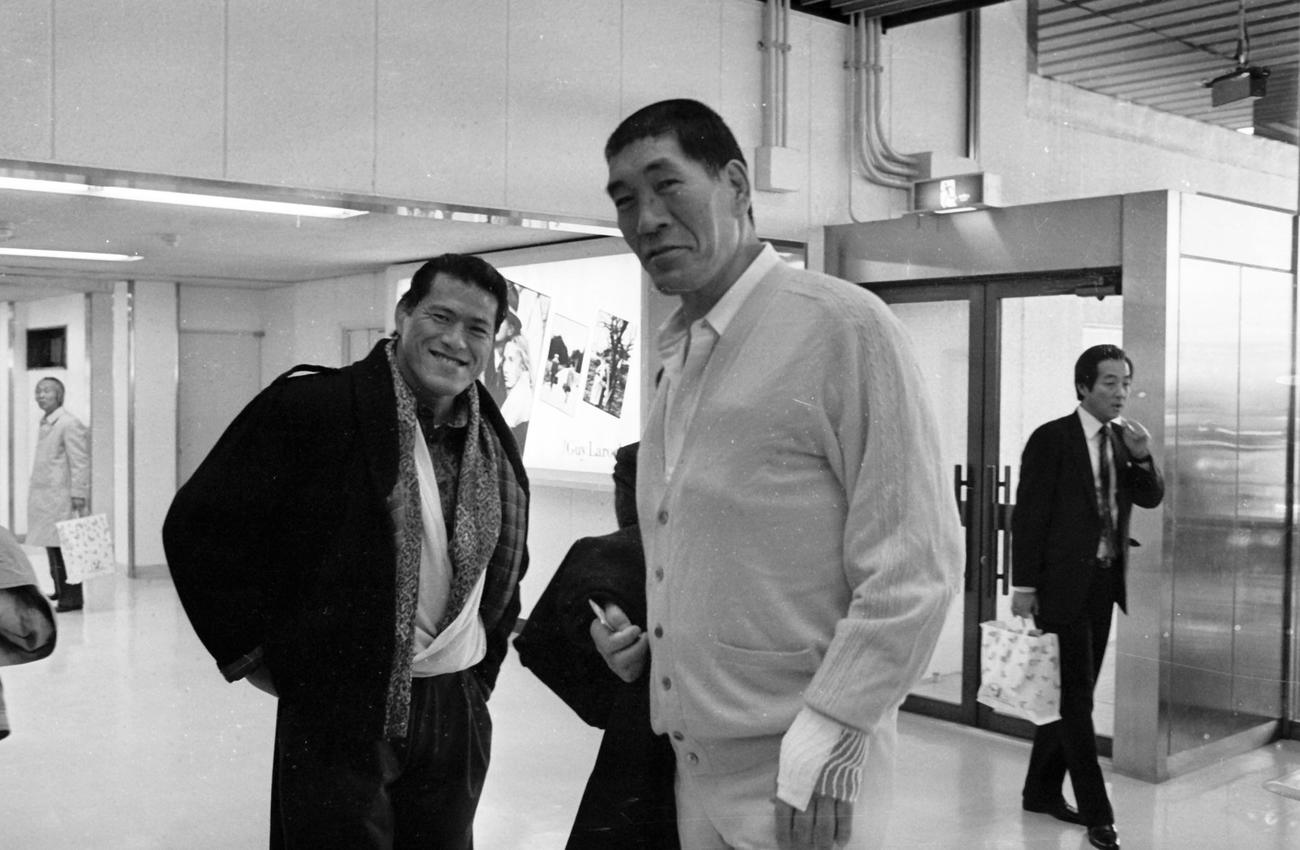 1987年11月24日、羽田空港でニアミスし笑顔をみせるアントニオ猪木さんとジャイアント馬場さん