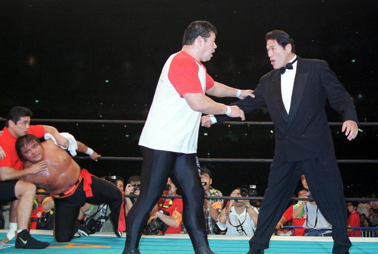 新日本「FINAL DOME」NWA世界ヘビー級選手権　橋本対小川の一戦に突然乱入したアントニオ猪木はレフェリーを務める藤波辰爾（左）に制止される。後方右はグロッキー状態の橋本真也（1999年10月11日撮影）