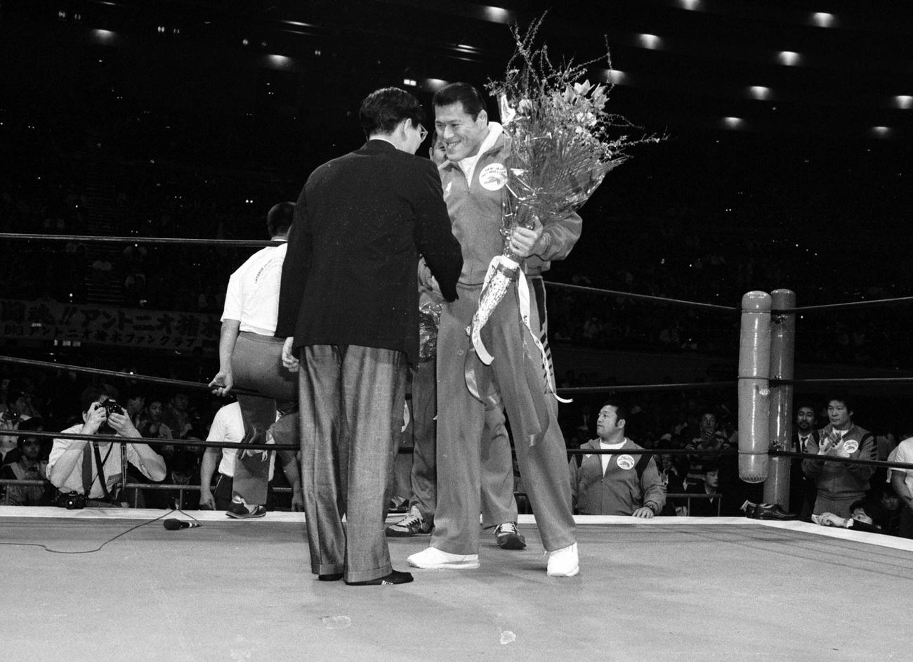 87年3月26日、最後の実況となったテレ朝古舘伊知郎アナ（左）に笑顔で花束を渡すアントニオ猪木