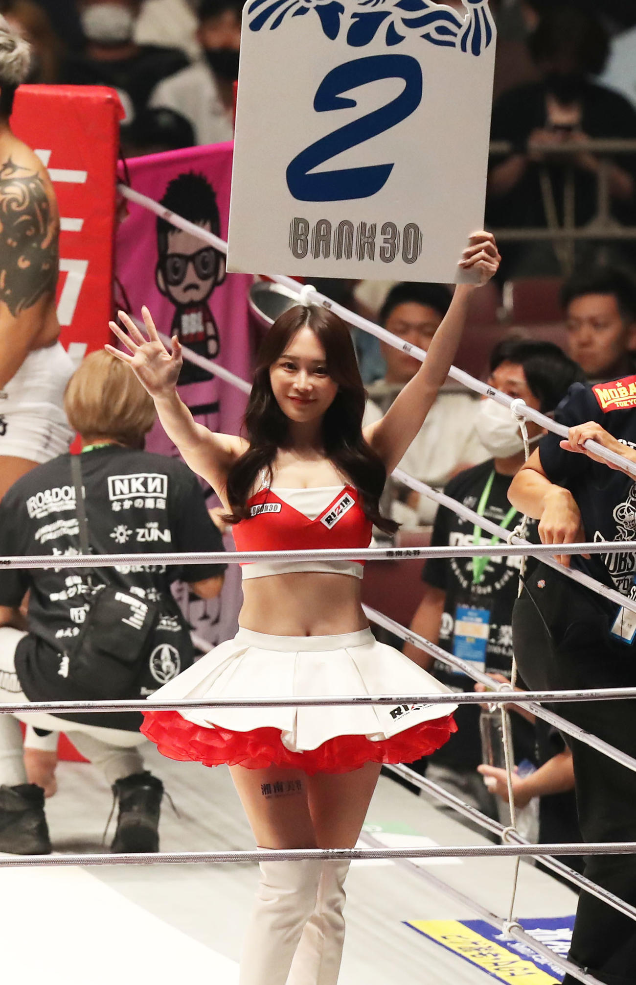 佐々木信治対宇佐美正パトリック　2回を示すボードを掲げ、観客に手を振るRIZINガール（撮影・屋方直哉）