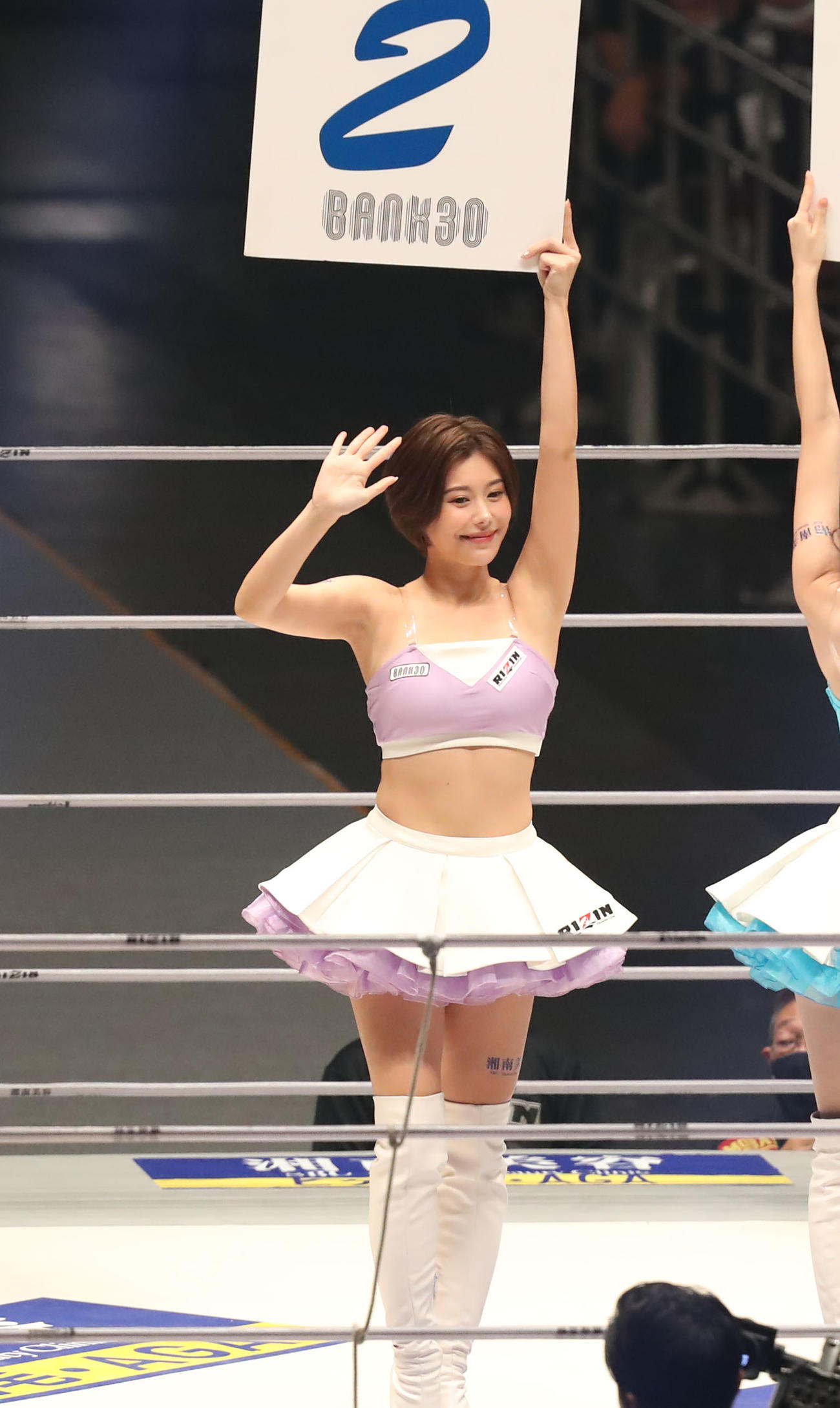 矢地祐介対ボイド・アレン　2回を示すボードを掲げ、観客に手を振るRIZINガール（撮影・屋方直哉）