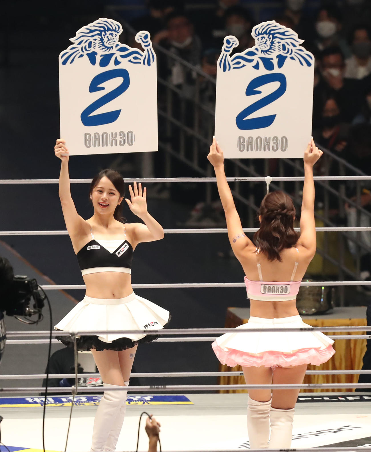 牛久絢太郎対クレベル・コイケ　2回を示すボードを掲げ、観客に手を振るRIZINガール（撮影・屋方直哉）