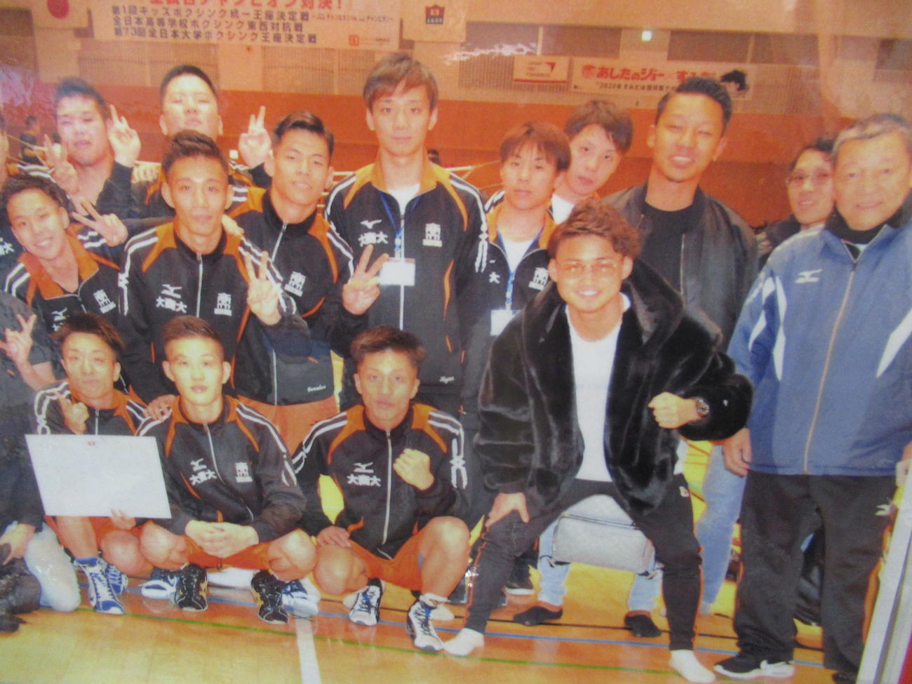 大商大ボクシング部に貼られている京口（前列右から2人目）との記念写真。右は菅原監督（大商大提供）