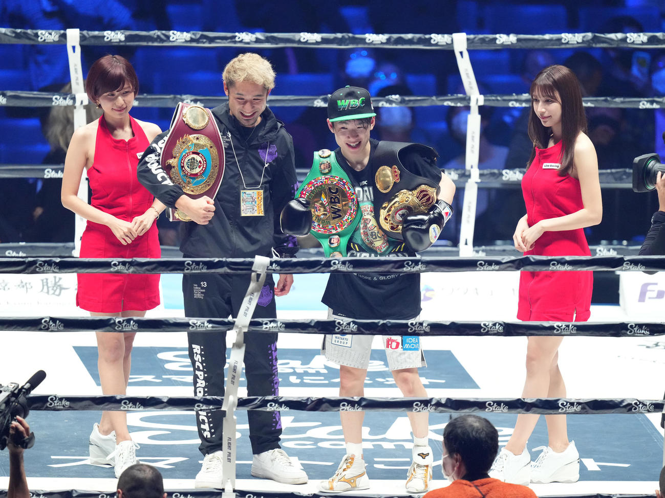 世界ライトフライ級2団体王座統一戦で勝利し、2本のベルトを肩にかけ、記念写真に納まる寺地（右から2人目）。右端は雪平莉、左端は天野麻菜（撮影・菅敏）