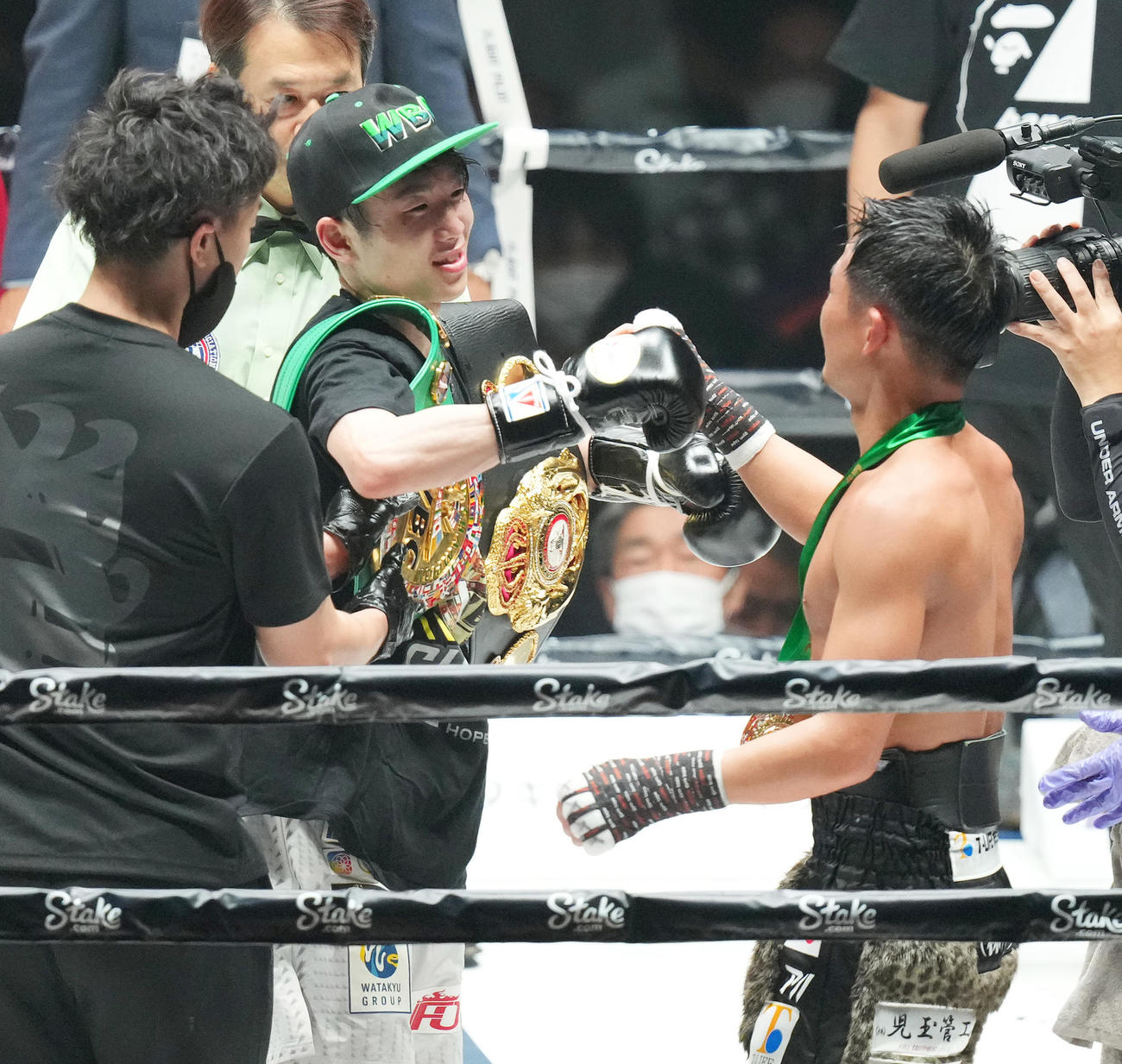 世界ライトフライ級2団体王座統一戦で勝利し、2本のベルトを肩にかけ、対戦者の京口（右）に祝福される寺地（撮影・菅敏）